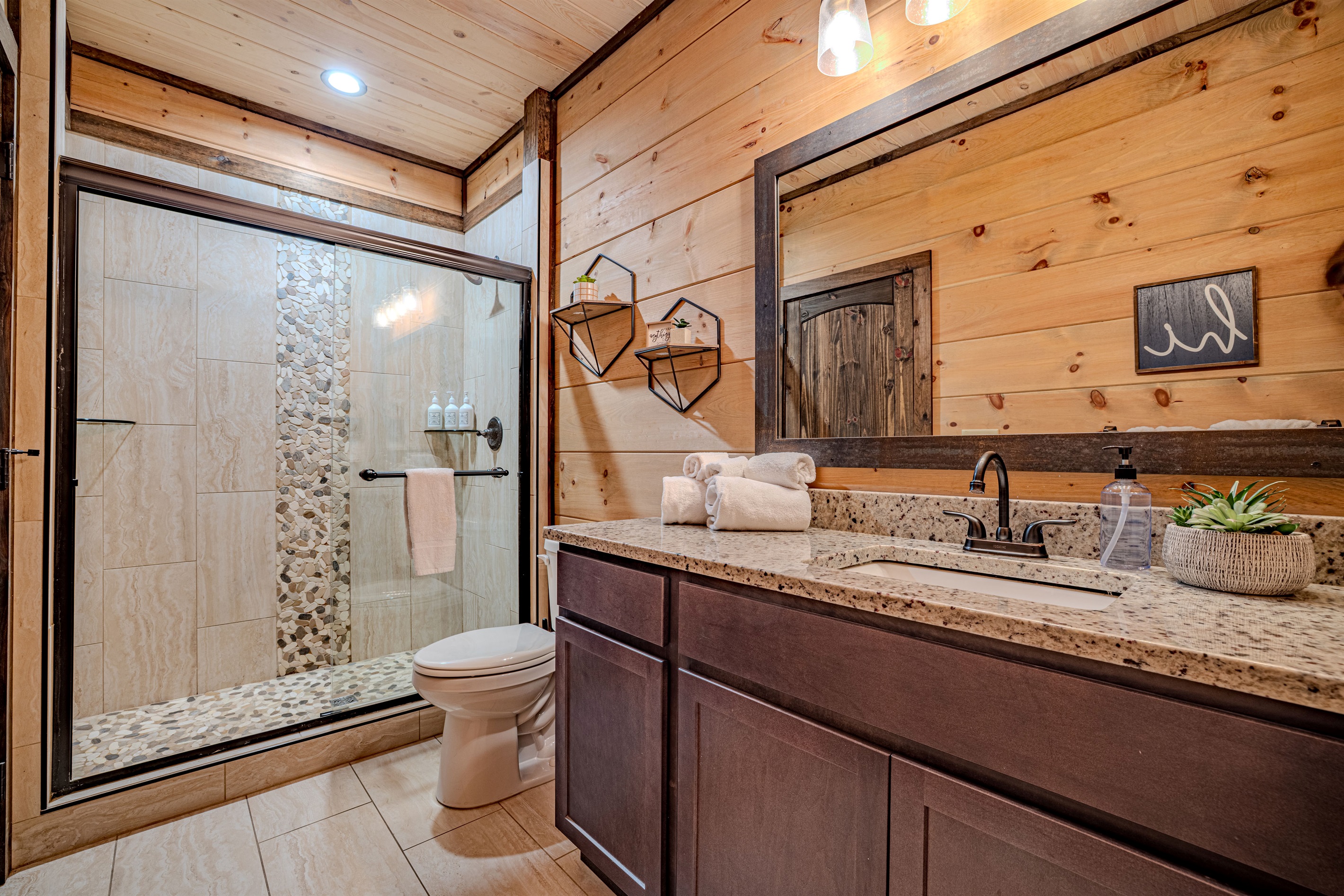 Second full bathroom with double vanity and stone-accent shower.