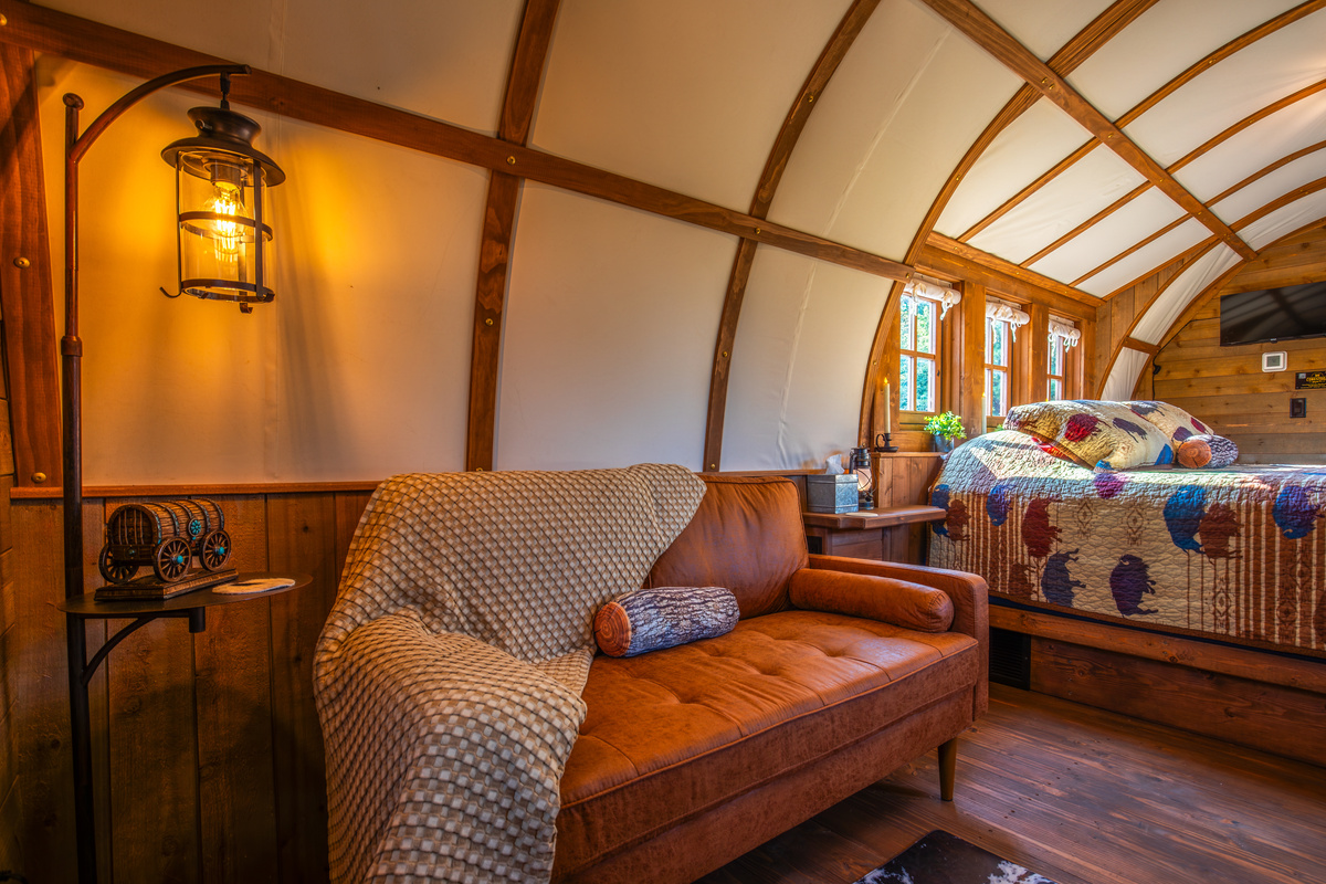 Cozy loveseat sitting area with soft throw blanket, lantern lighting, and rustic western decor.