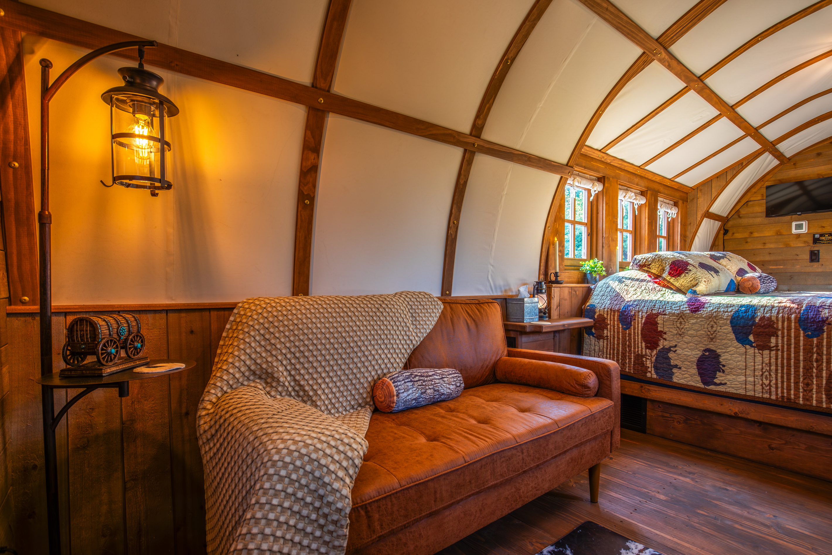 Cozy loveseat sitting area with soft throw blanket, lantern lighting, and rustic western decor.