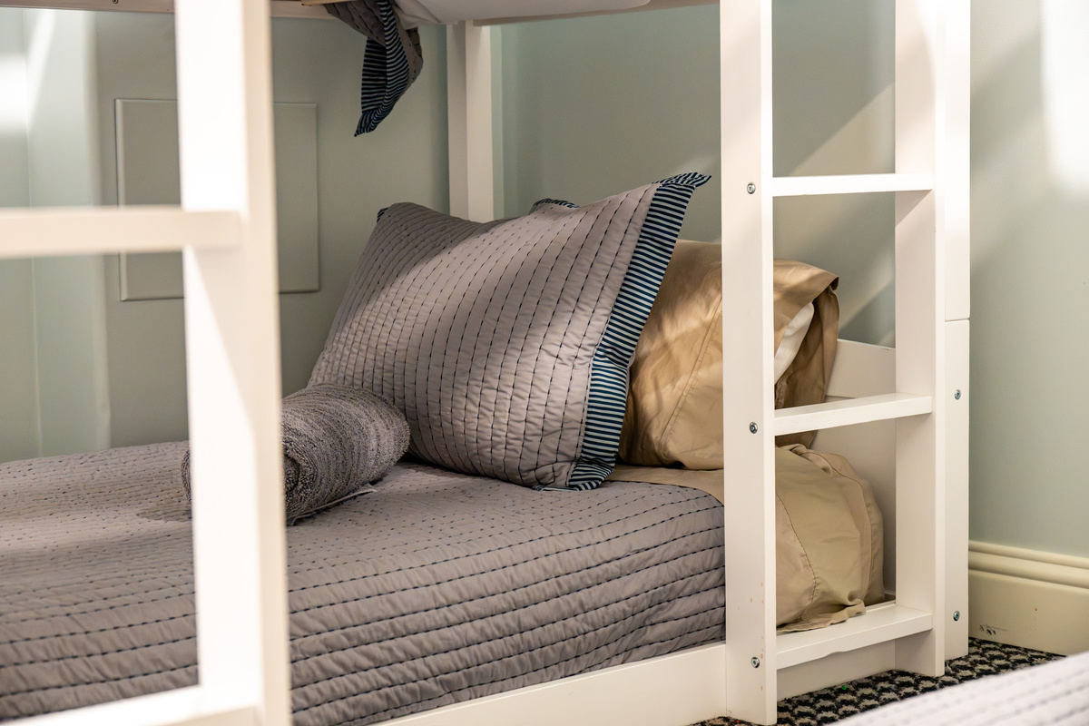 Each bunk is neatly prepared with coordinated bedding and fresh towels, creating a clean and welcoming space for every guest.