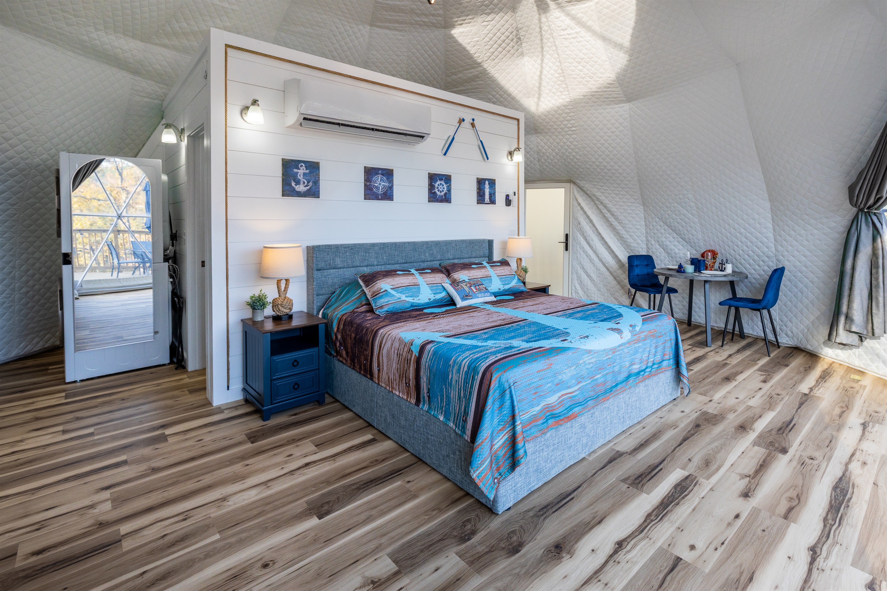 Bright, spacious king bedroom with cozy lighting, nautical décor, and a dining area tucked perfectly into the dome’s open layout