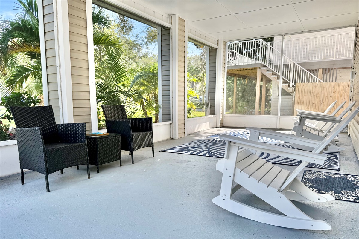 Enjoy morning coffee or evening cocktails in this serene screened-in patio with comfortable seating and tropical views.