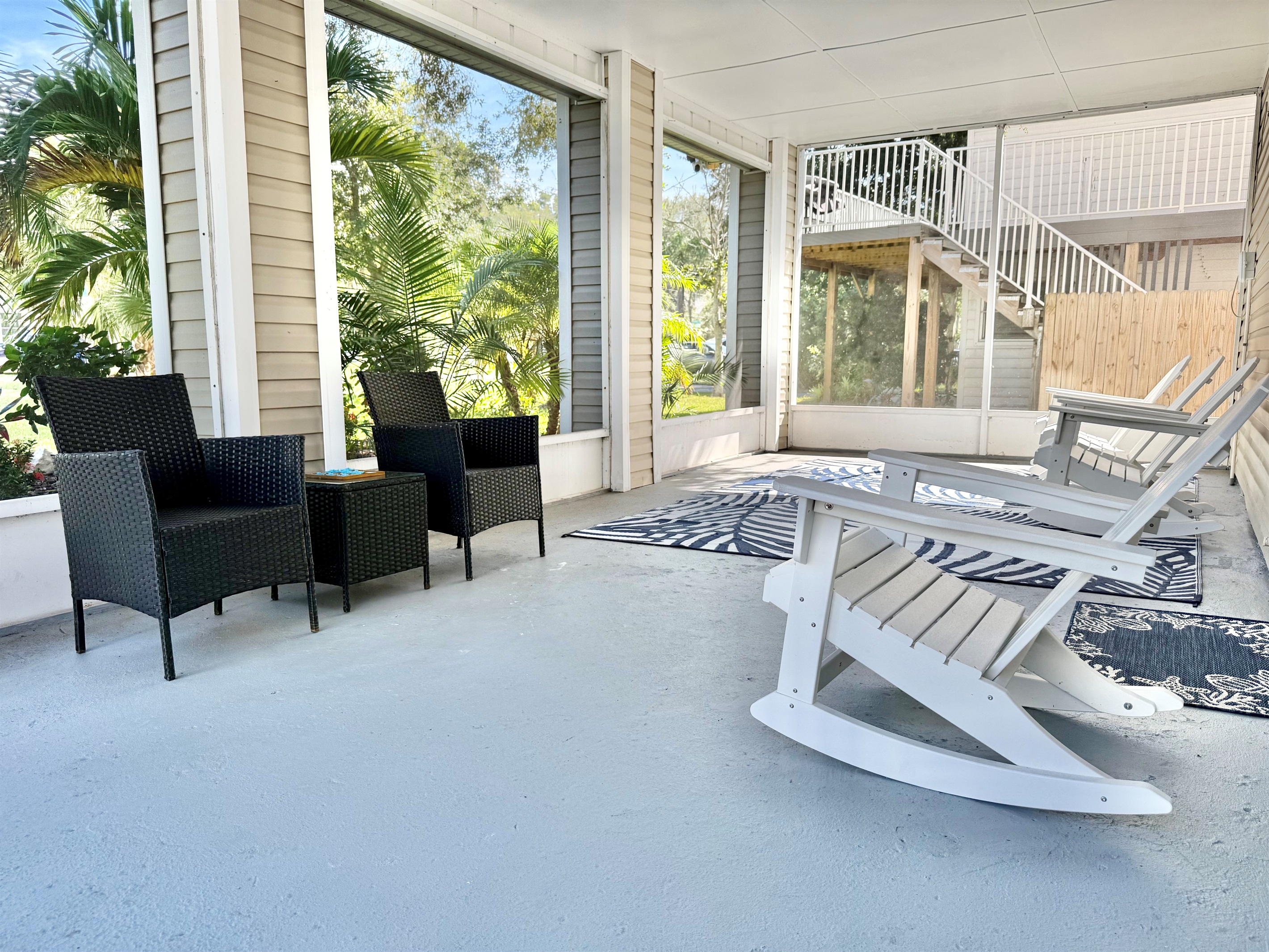 Enjoy morning coffee or evening cocktails in this serene screened-in patio with comfortable seating and tropical views.