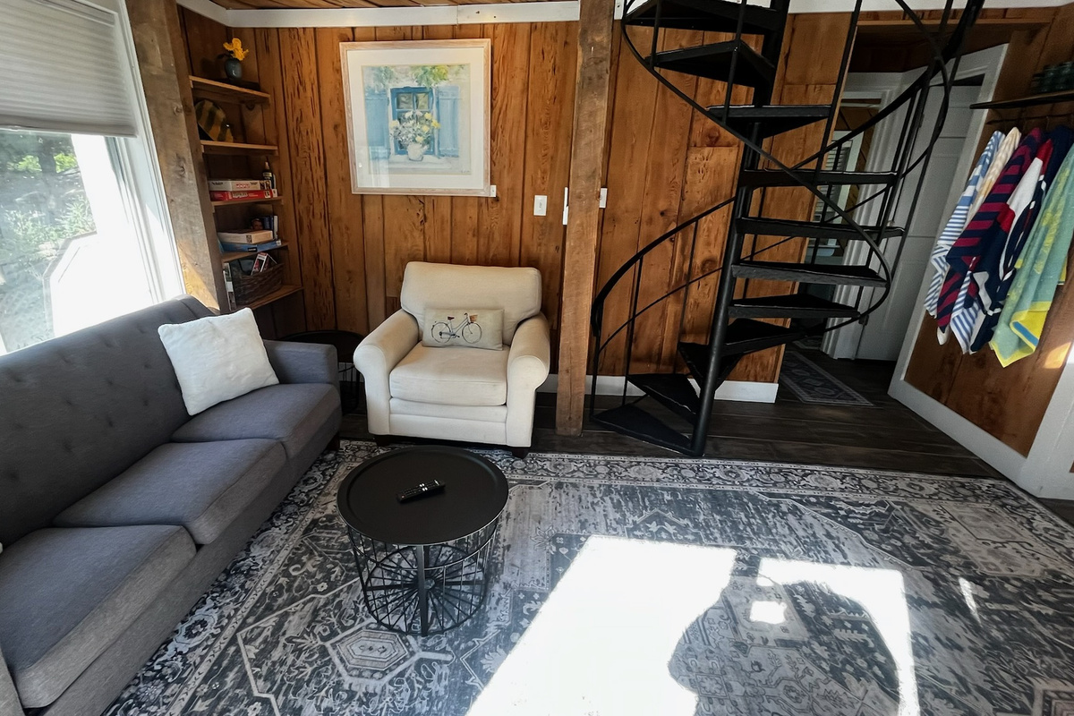 Living room with TV, wifi, and remote controlled ac/heat split system unit. Couch turns into a sleeper.
