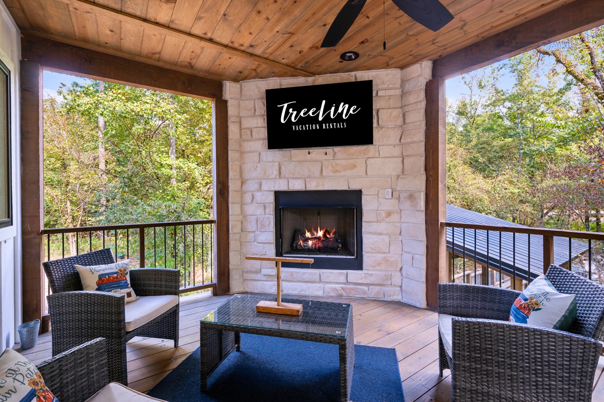 Screened porch with fireplace and cozy seating.