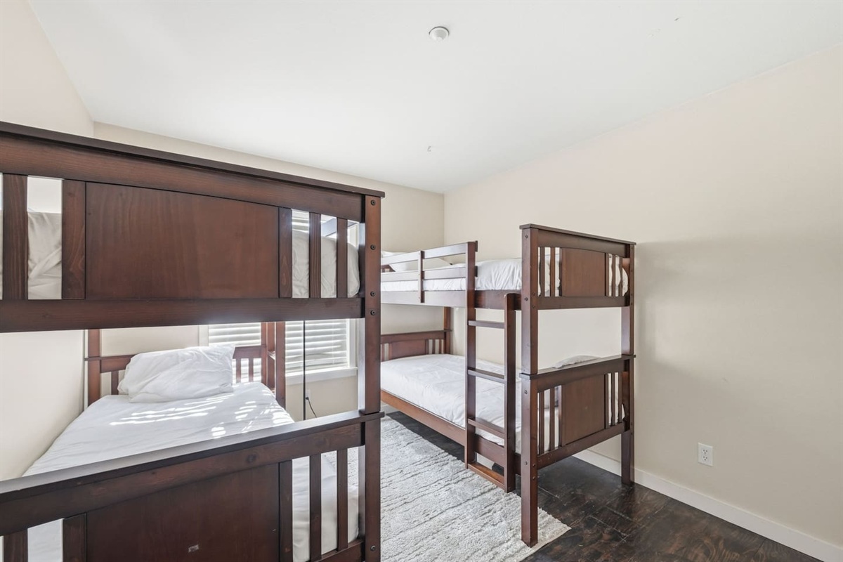 Bunk room with two sets of twin bunk beds, sleeps 4. Room-darkening shades, bed linens, and extra pillows and blankets provided. Ideal for kids and large family groups.