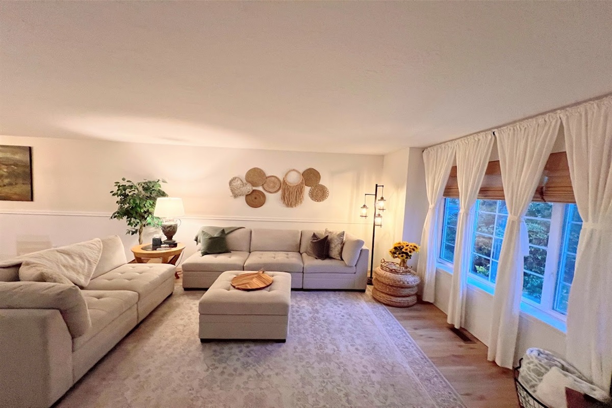 Living room has a sectional to provide seating for all as well as a Smart TV, books, games, and cozy blankets aboud. 