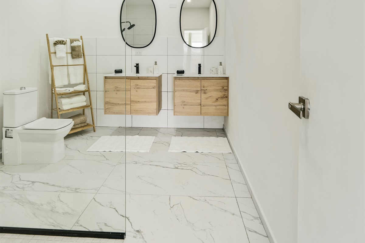 Full Bathroom Featuring Double Vanity, Ample Storage & Modern Toilet