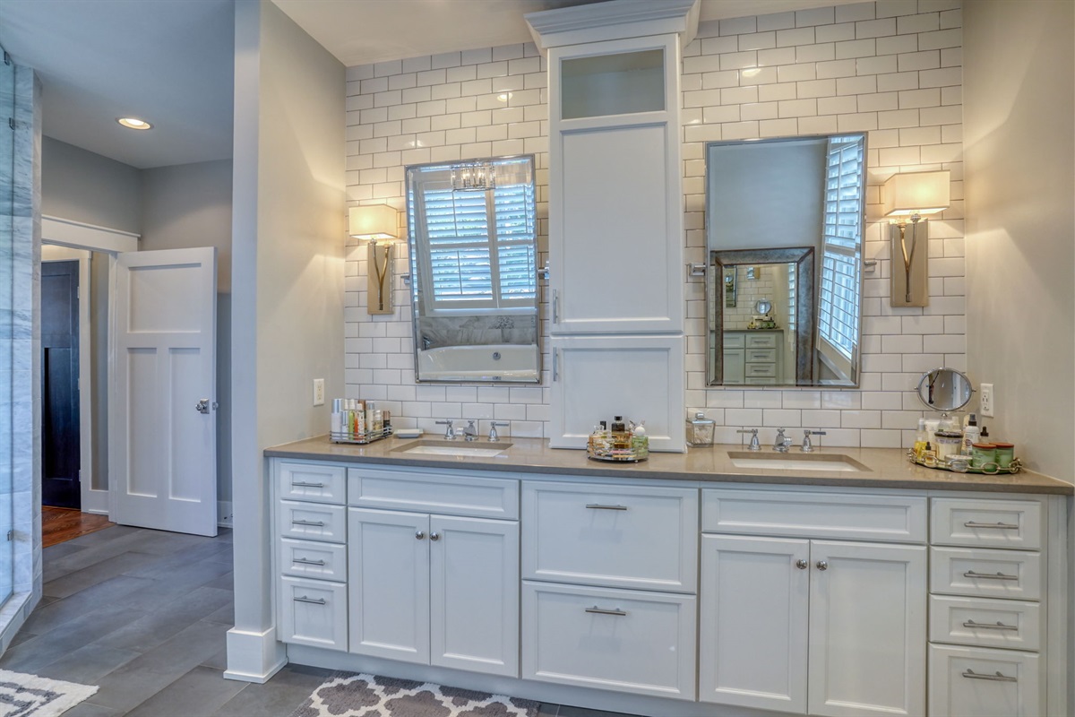 Spa-style primary bath with heated floor and dual vanities