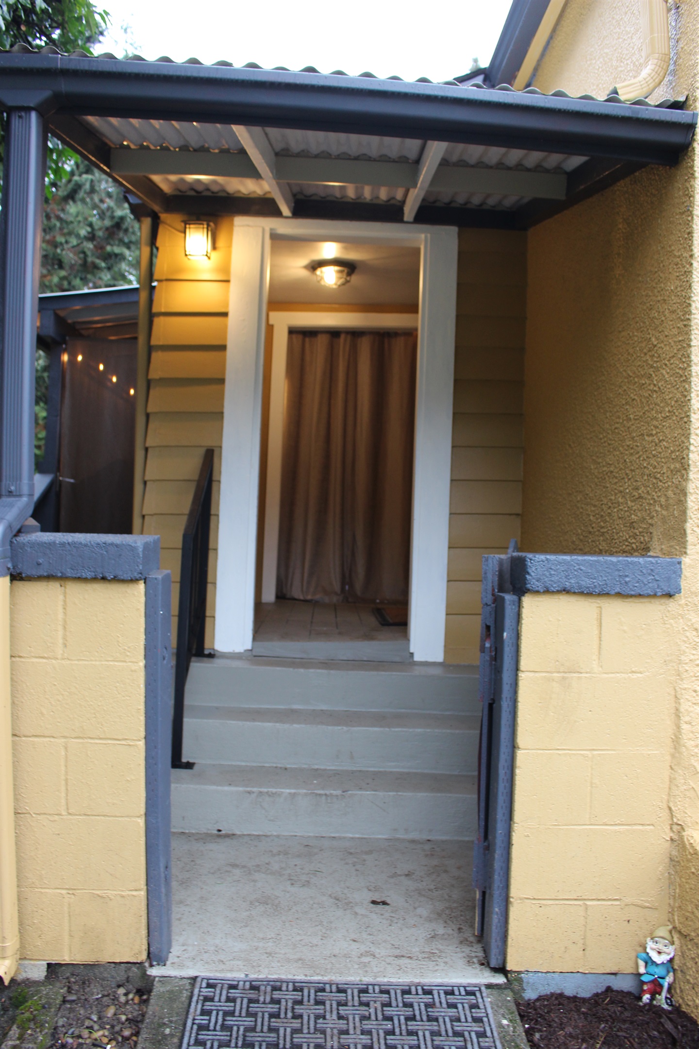 Gated back porch area with steps up to porch. New guard rail added for safety