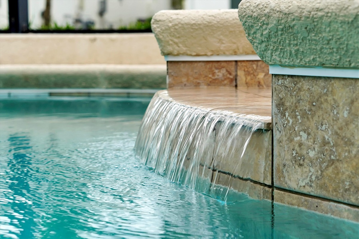 The hot tub overflows to the main pool, and has the same water temperature