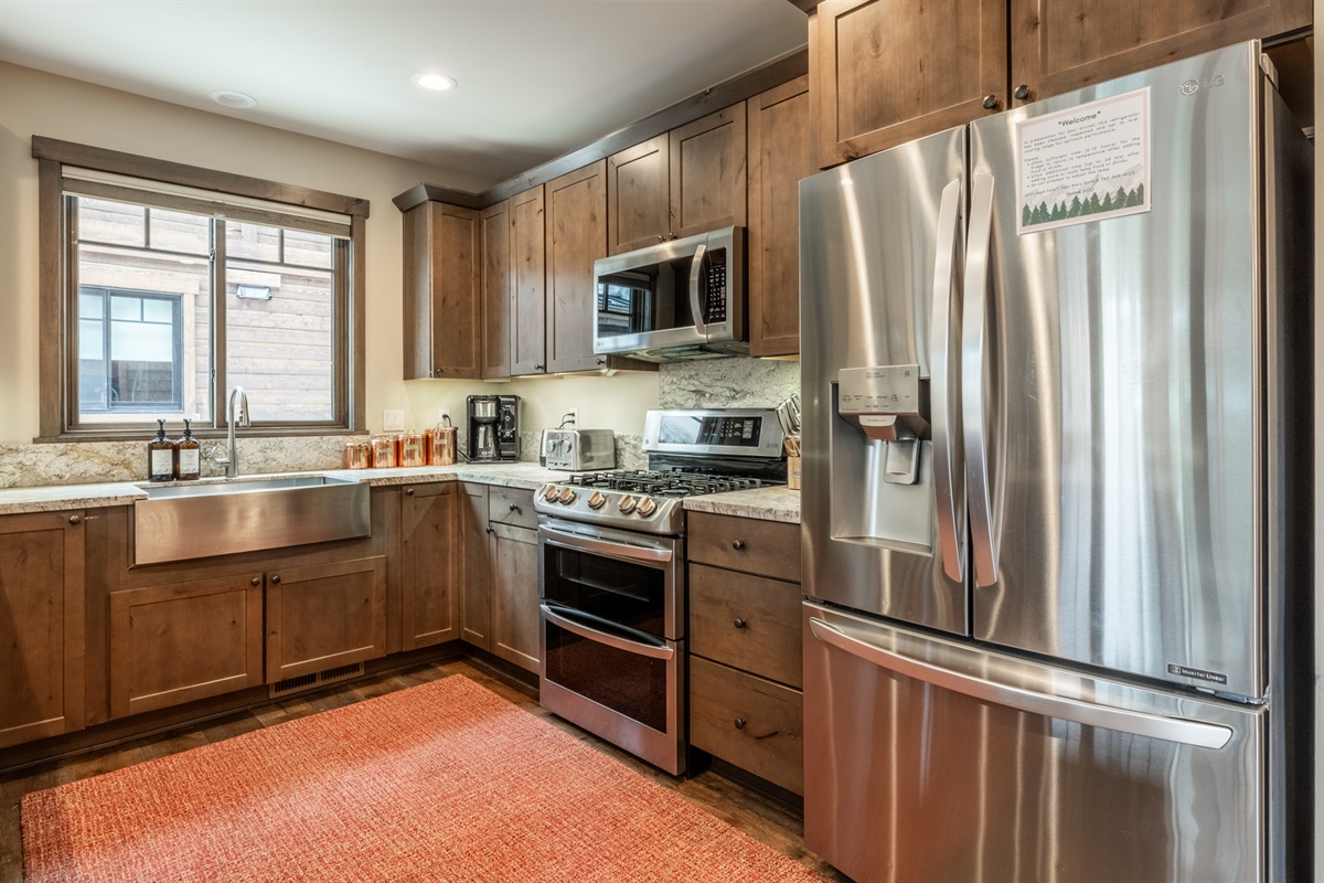 Dual ovens, gas range, beverage fridge, and thoughtful layout make cooking for a crowd effortless.