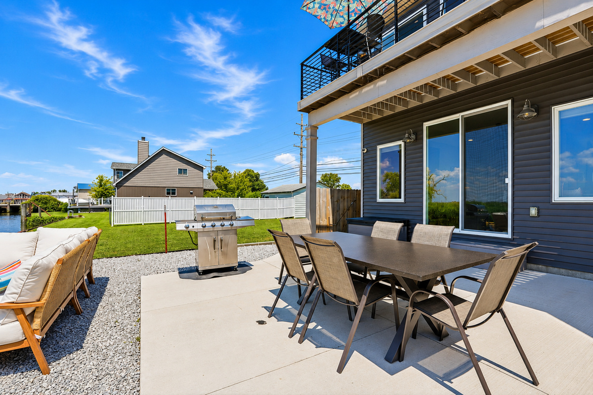 Enjoy waterfront dining with a spacious outdoor table, gas grill, and comfortable seating—perfect for family meals, BBQs, and relaxing evenings by the water.