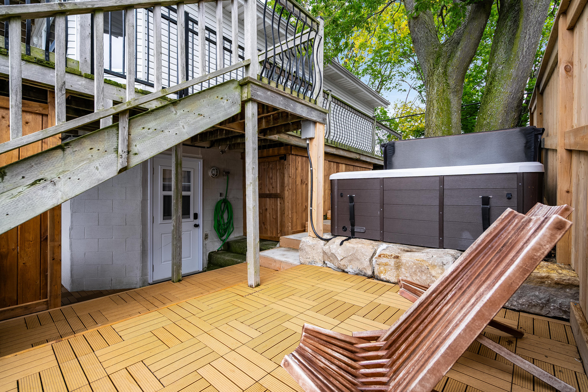 Expansive outdoor entertaining area with hot tub and comfortable lounge seating.