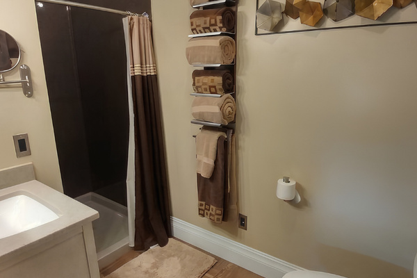 Main level bathroom includes a sink, shower and a dual flush commode to save water