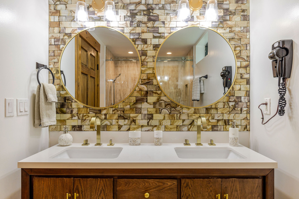 The lower-level bathroom features a stylish double vanity with dual sinks, elegant finishes, and plenty of space for guests to get ready with ease.
