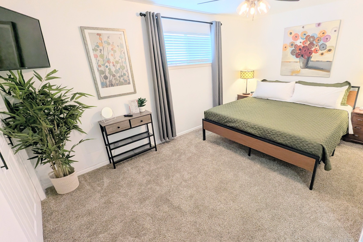 Designed for comfort, the king bedroom includes blackout curtains, a ceiling fan, charging stations, Roku TV, closet space, and plenty of plush pillows and bedding.