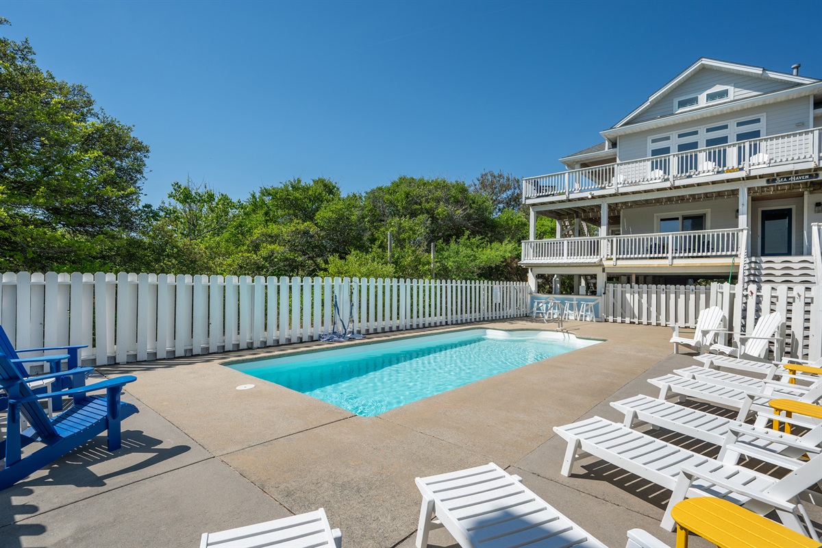Spacious pool deck with loungers perfect for swimming, sunbathing, and unwinding.