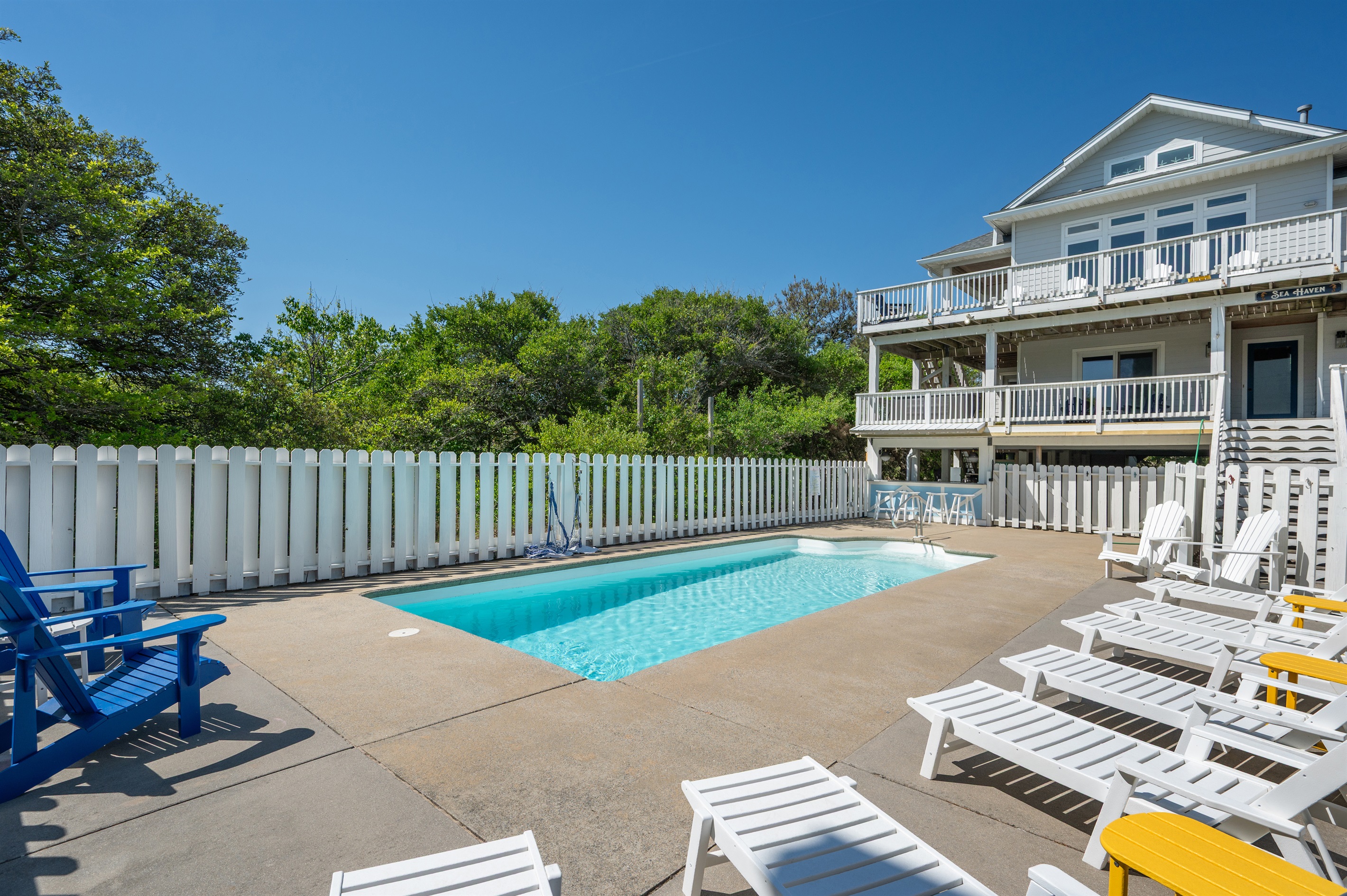 Spacious pool deck with loungers perfect for swimming, sunbathing, and unwinding.