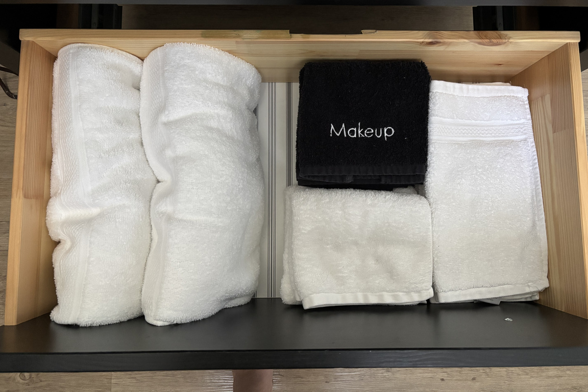 Fresh bath towels and a black makeup cloth are provided for guest use.