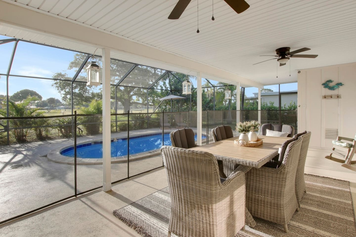 Outdoor dining overlooking the pool and golf course under the cooling fans. Both indoor and outdoor dining tables are available so everyone will be happy.  Pool safety fence keeps area secure.