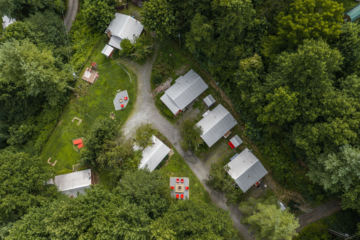 Unique Retreat: Discover a charming cluster of cabins surrounded by vibrant greenery and fire pits!