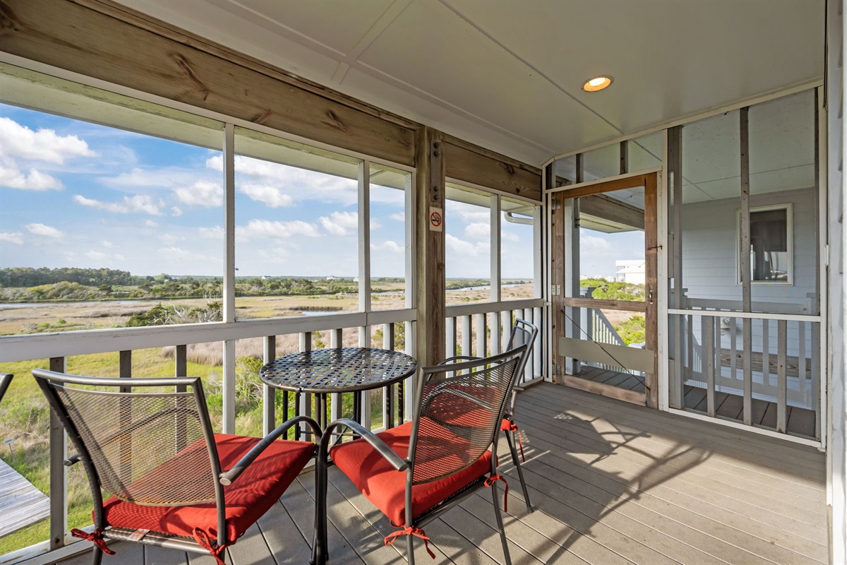 Covered screened porch with table seating, perfect for morning coffee or evening conversations