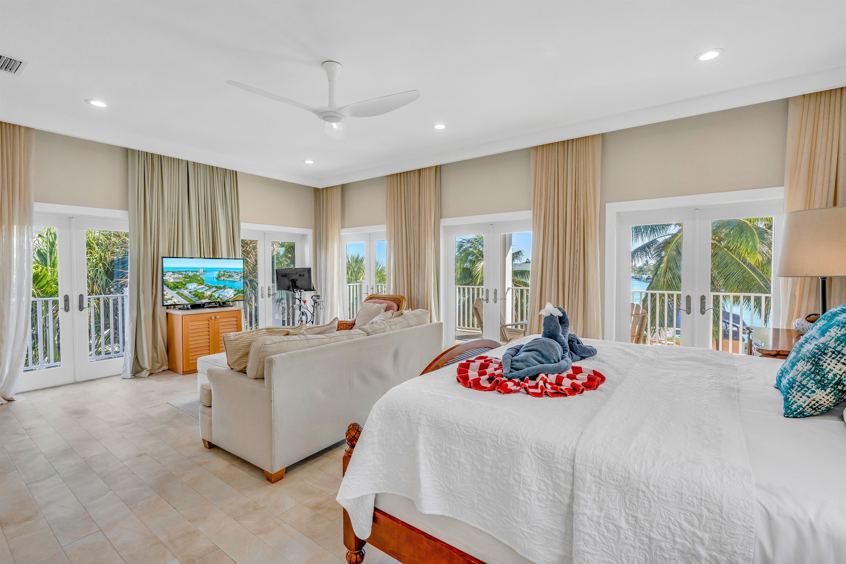 Windows and doors wrap around three sides of the room, with spectacular open water views.