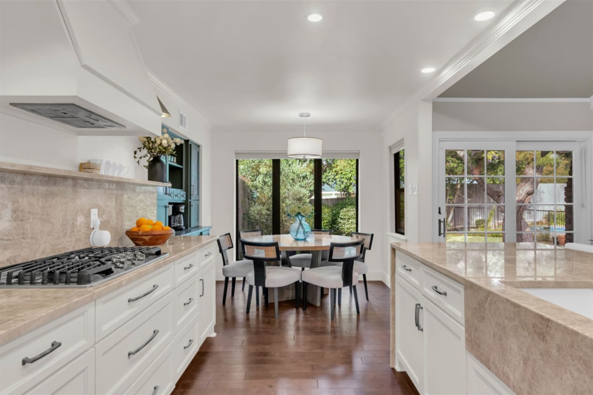 Kitchen nook dining area seating six, set within an open-concept layout that flows seamlessly into the living room and fully equipped kitchen.