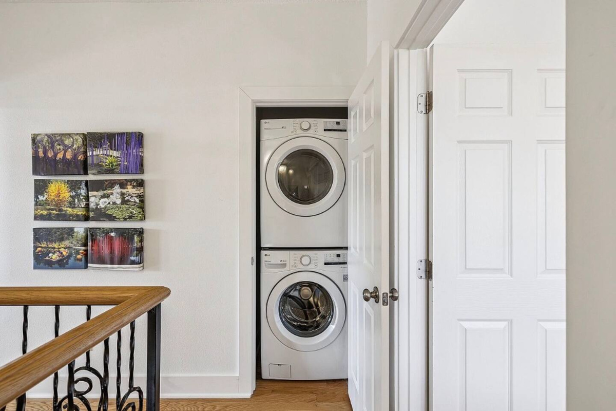 Convenient upstairs laundry closet featuring a stackable washer and dryer for easy clothes and beach towel care during your stay.