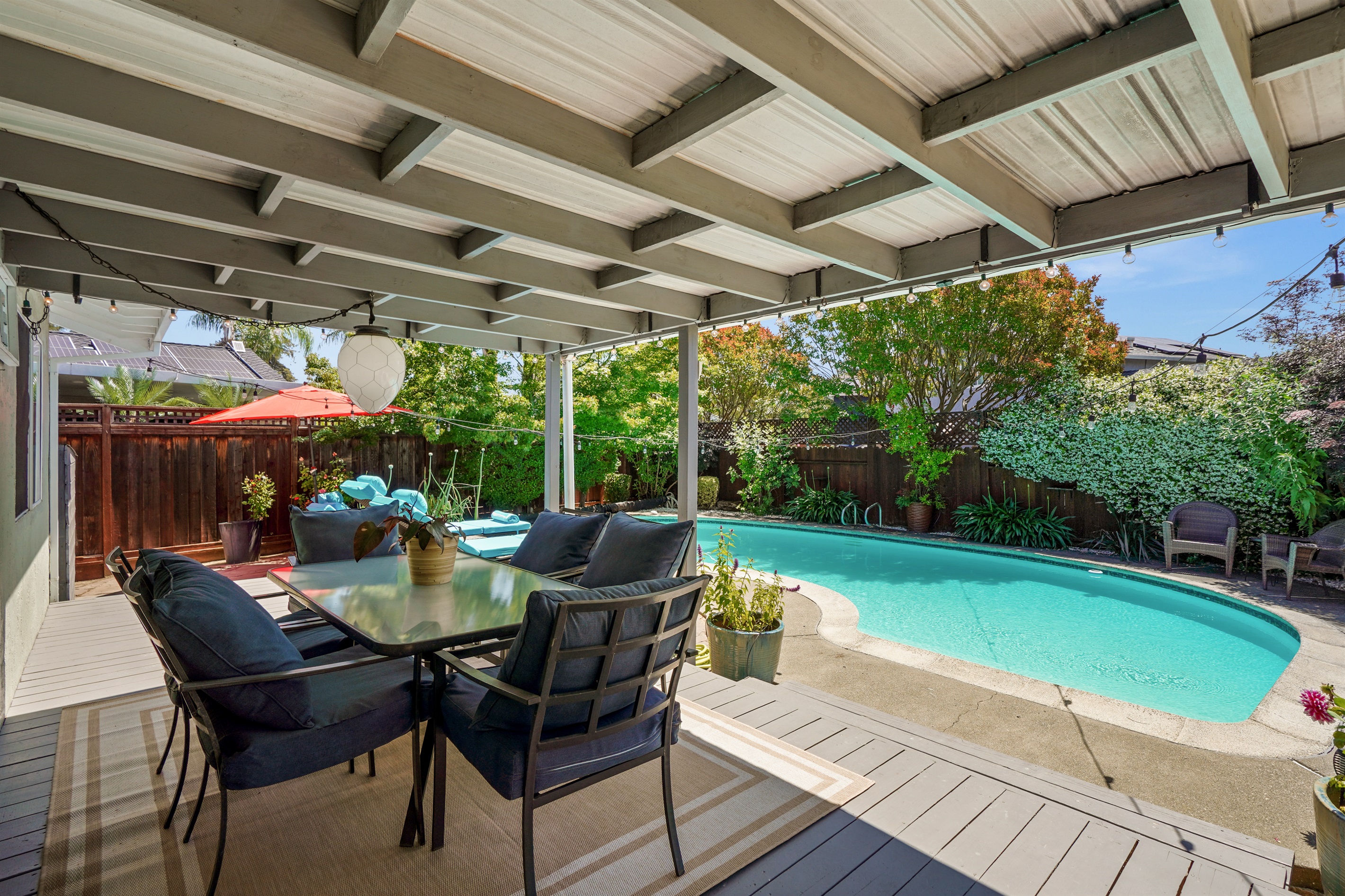 Private backyard retreat with a sparkling pool, outdoor seating, and space to relax and enjoy Napa Valley’s beautiful weather.