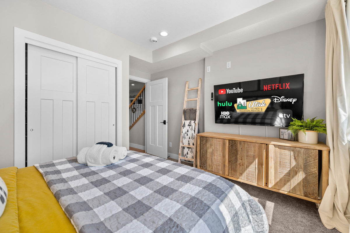 Upper-level king bedroom featuring a Smart TV, plush bedding, and a relaxing retreat after a day of skiing, hiking, or exploring.