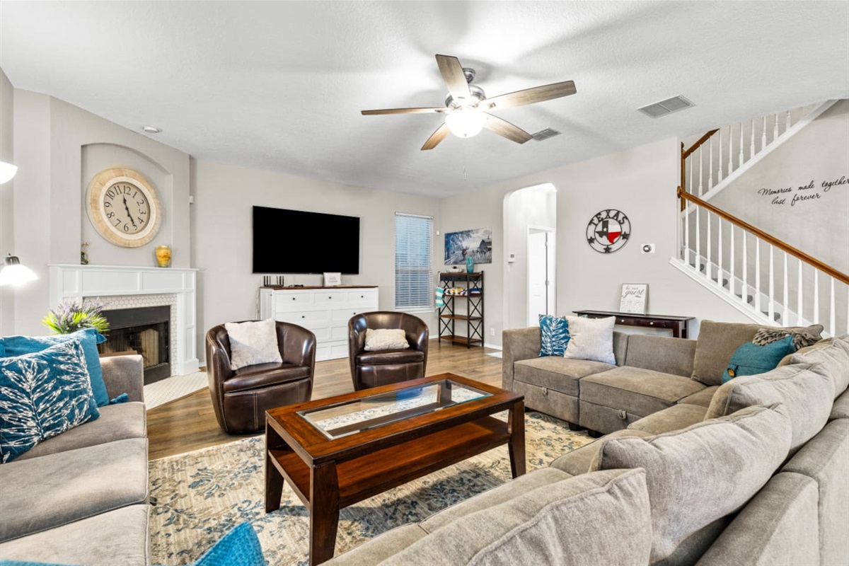 Spacious living room with Smart TV, plush seating, and a dresser that pulls out into a bed, offering flexible sleeping space for groups and families.