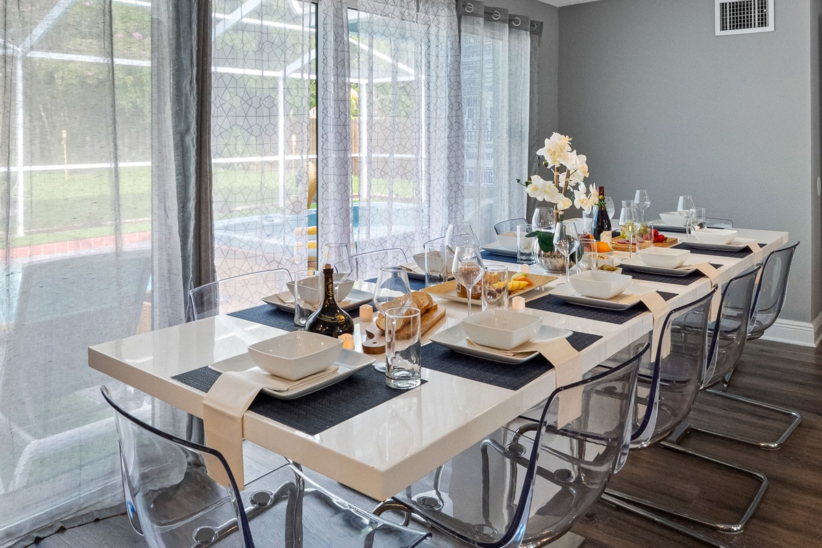 With its glossy white dining table and acrylic chairs, this space exudes a clean, minimalist vibe that complements the home’s modern aesthetic.