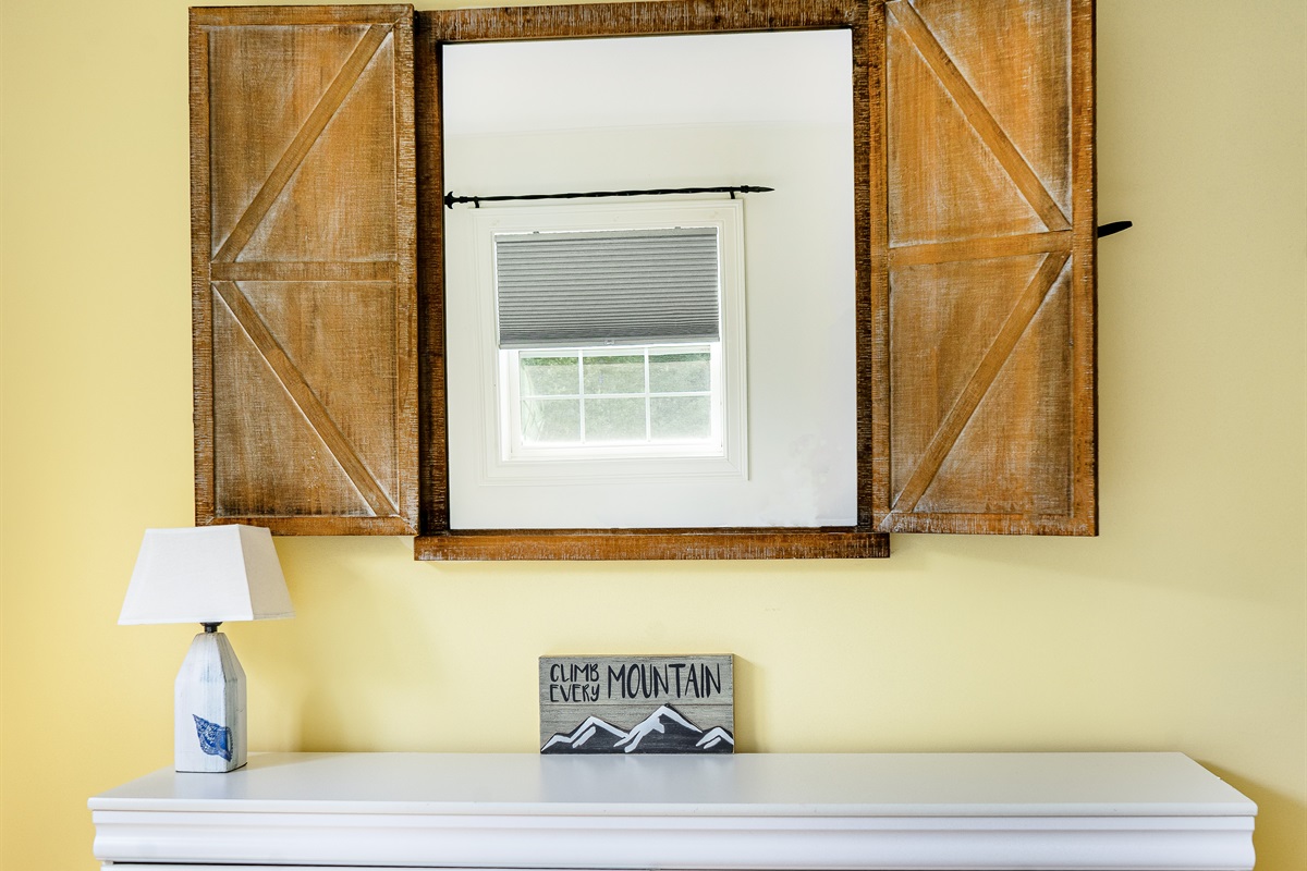The Butterfly Room features a large dresser for all your belongings and a unique barn-door style mirror. Charming details like the "Climb Every Mountain" art highlight the adventurous spirit of your Southwest Harbor vacation near Acadia.