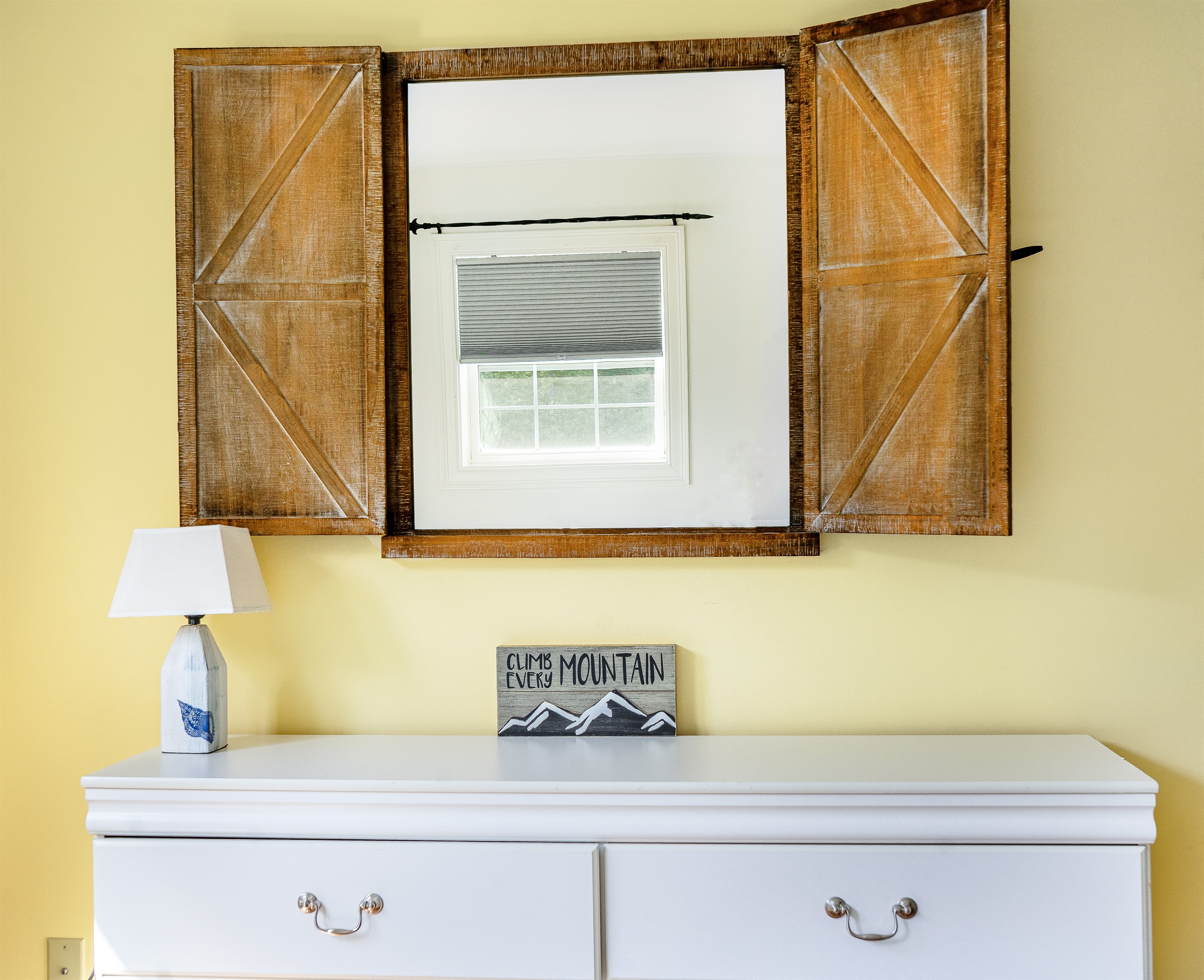 The Butterfly Room features a large dresser for all your belongings and a unique barn-door style mirror. Charming details like the "Climb Every Mountain" art highlight the adventurous spirit of your Southwest Harbor vacation near Acadia.