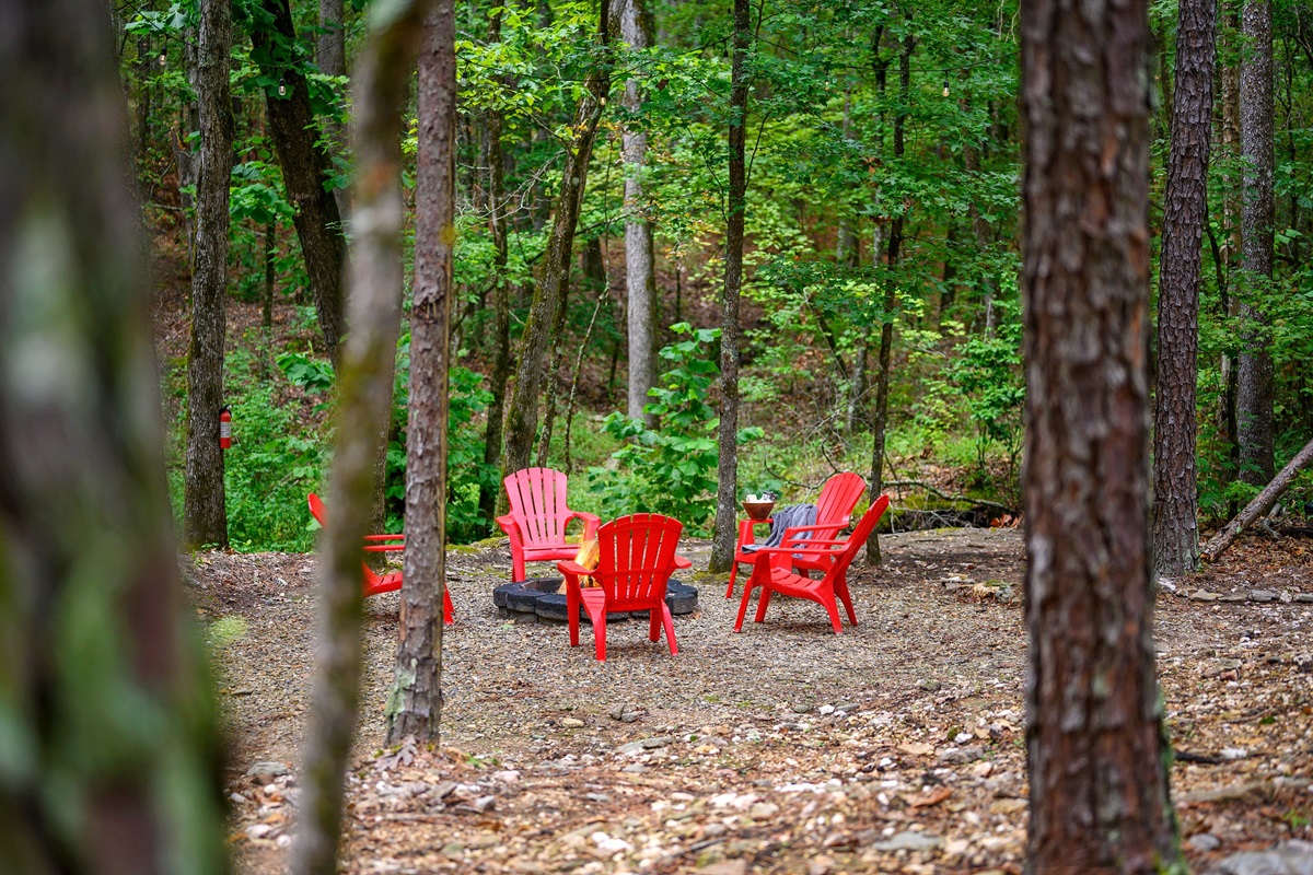 Firepit area sits down by the creek tucked into the forest for a true camp fire experience.