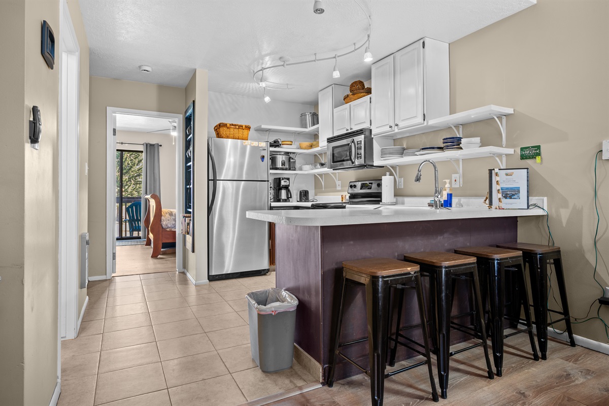 Breakfast bar with seating for four, opening to the kitchen and dining area for easy conversation.