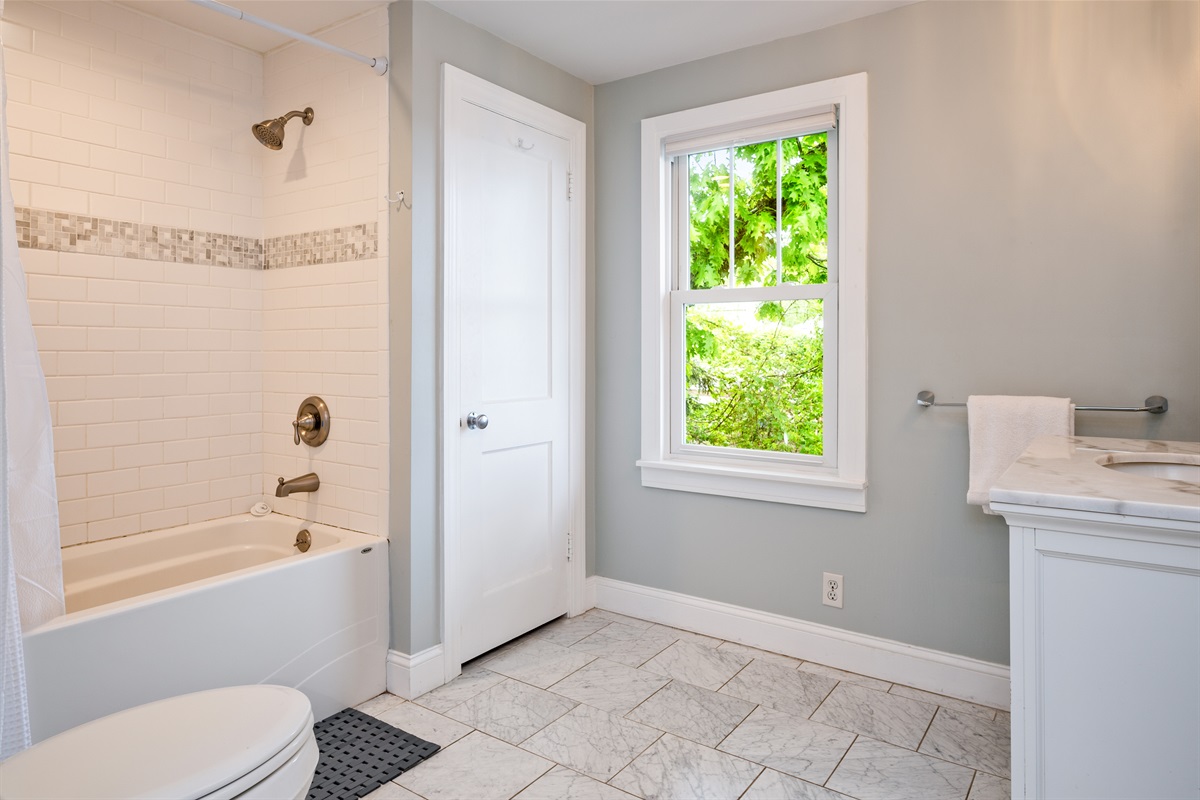 Modern full bathroom with a deep soaking tub, stylish tilework, and calming decor 🚿🛁🖼️