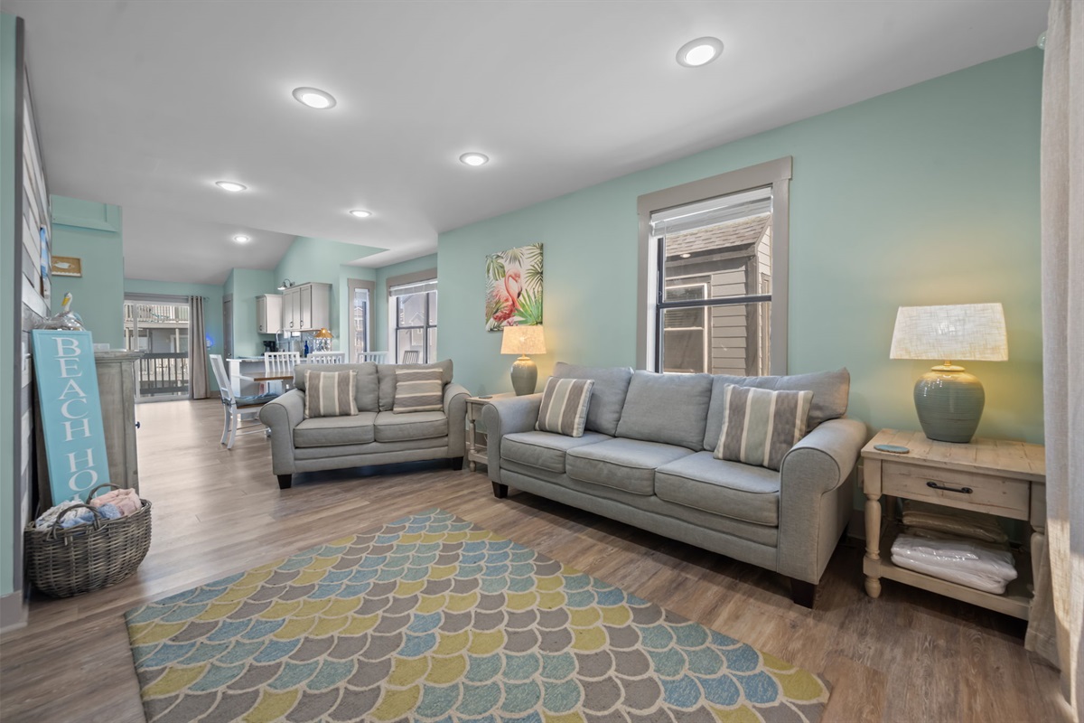 Bright, open-concept living space with comfortable sofas, coastal d&eacute;cor, and plenty of room to gather