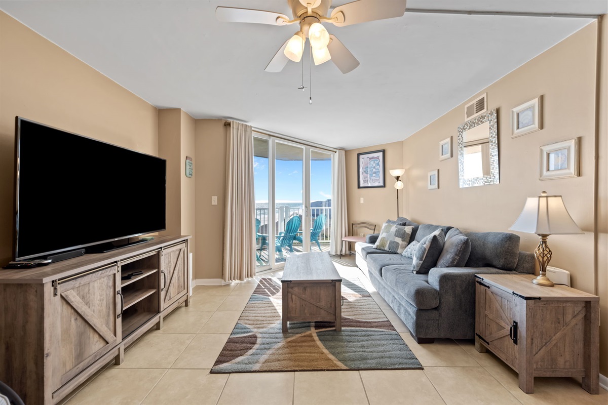 Spacious living room perfect for family time&mdash;comfortable sofa, large TV, and easy access to the balcony for fresh ocean air