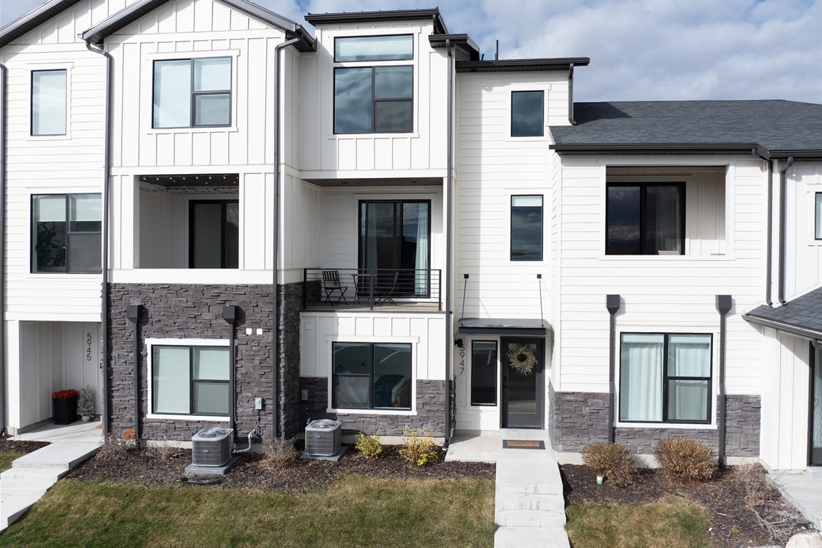 Front exterior featuring mountain backdrop and clean design.