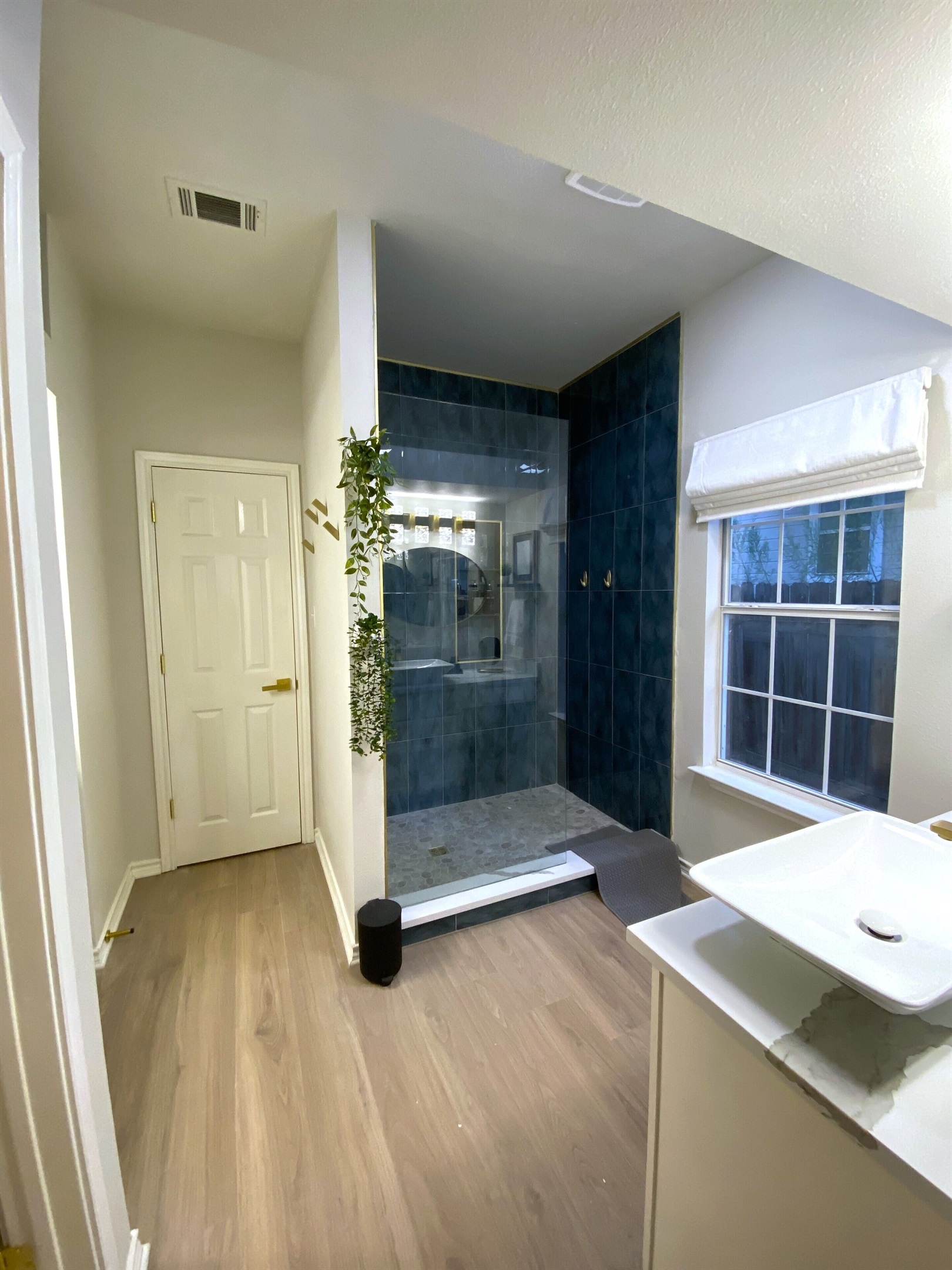 Indulge in luxury in this stunning en suite master bathroom! Enjoy the sleek, glass-enclosed shower with gorgeous blue tiles and gold accents, plus complimentary shampoo, conditioner, and shower gel. Your private oasis awaits—pamper yourself!