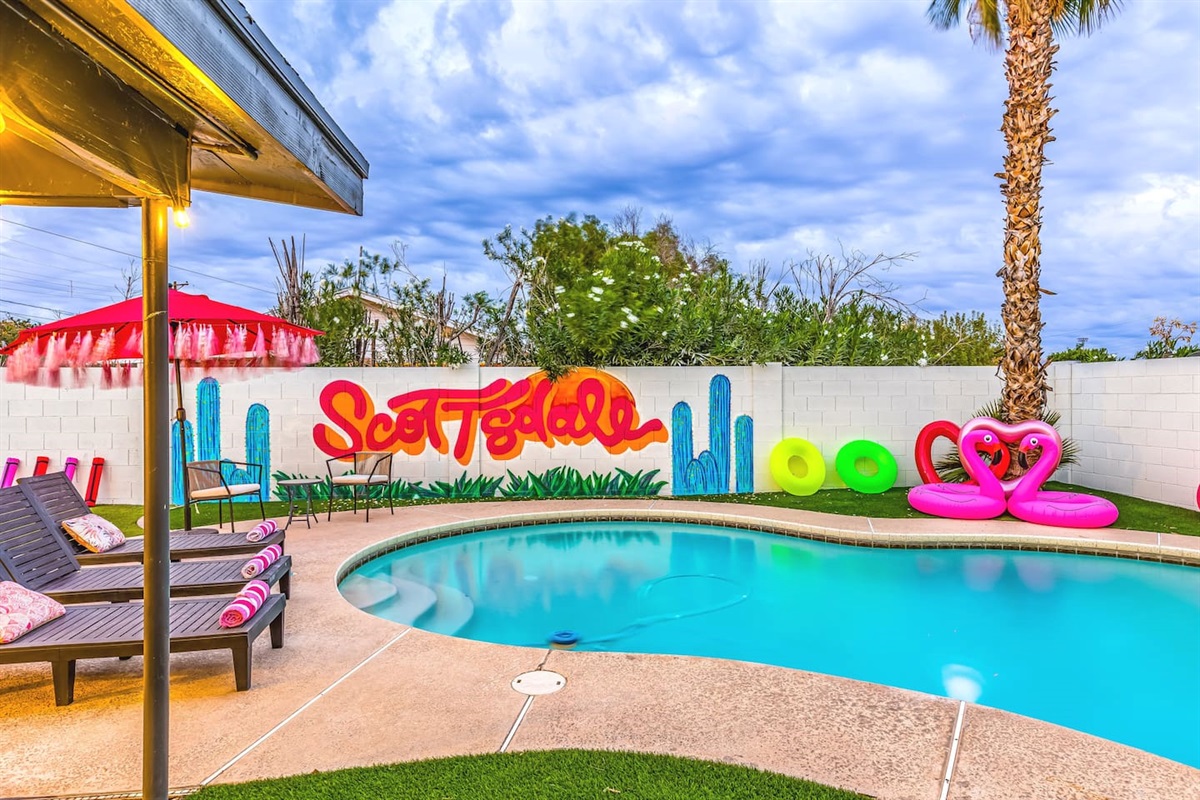 Pool days made colorful! Neon tubes, pink flamingos, and a desert mural create the ultimate Scottsdale pool party scene.

