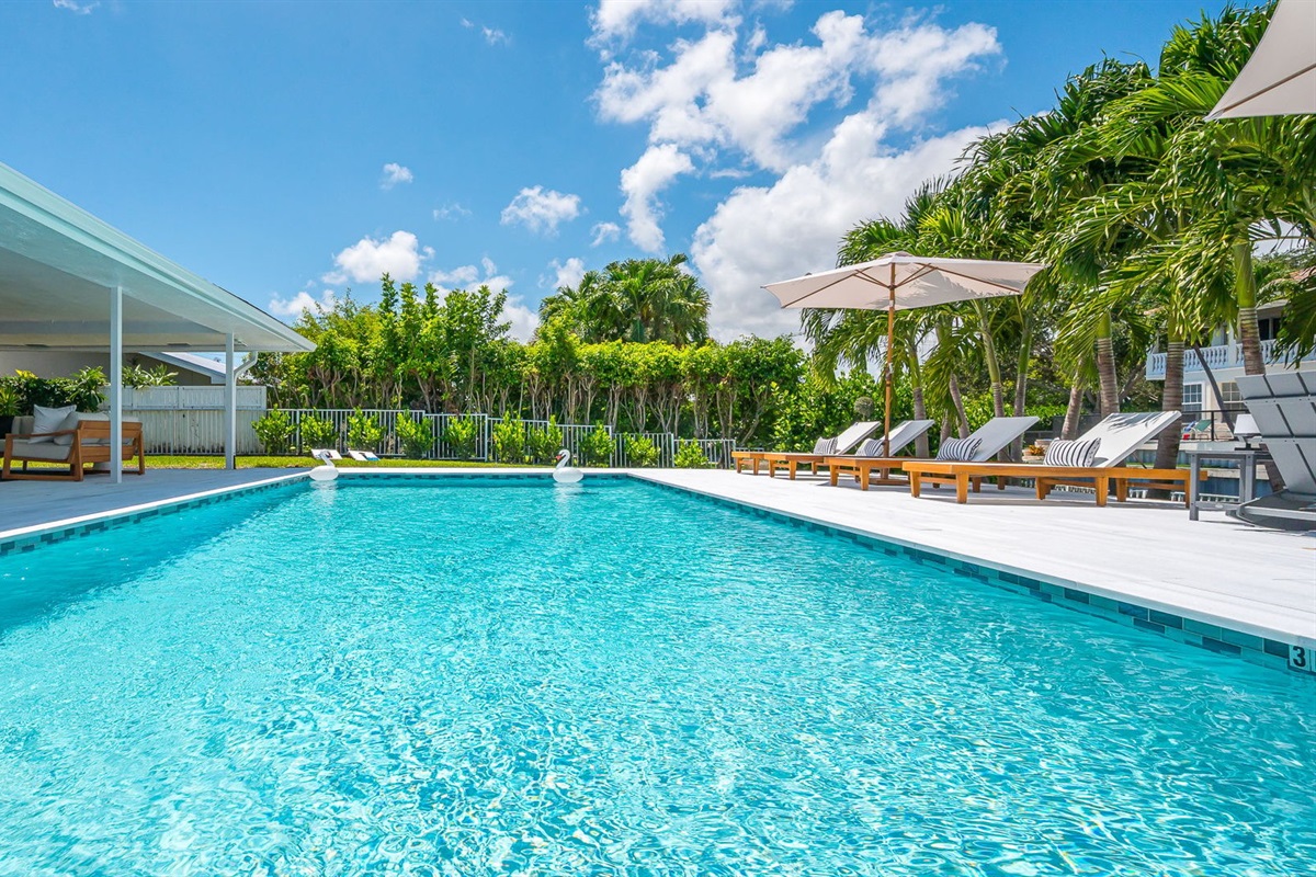 Spend your days lounging by the shimmering pool, dining al fresco under the covered patio, and unwinding in stylish outdoor living spaces—all set against a serene lakefront backdrop with private dock access