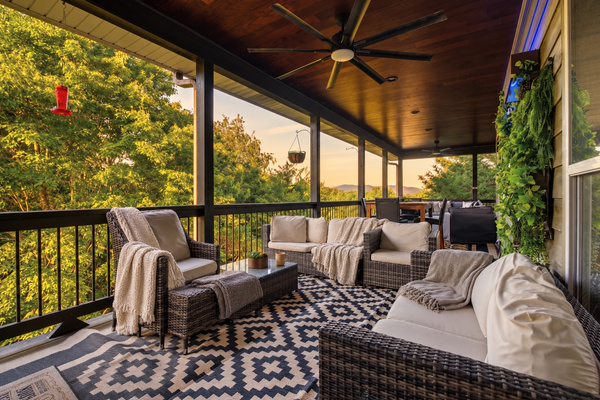 Covered back deck at sunset: outdoor living room with sectional, ceiling fans and Smoky Mountain views
