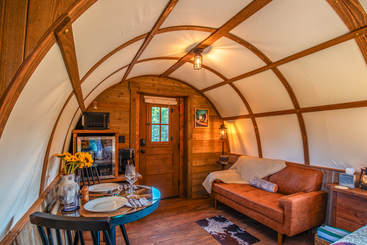 Comfortable sitting area, dining table, coffee station, and rustic western details inside the wagon.