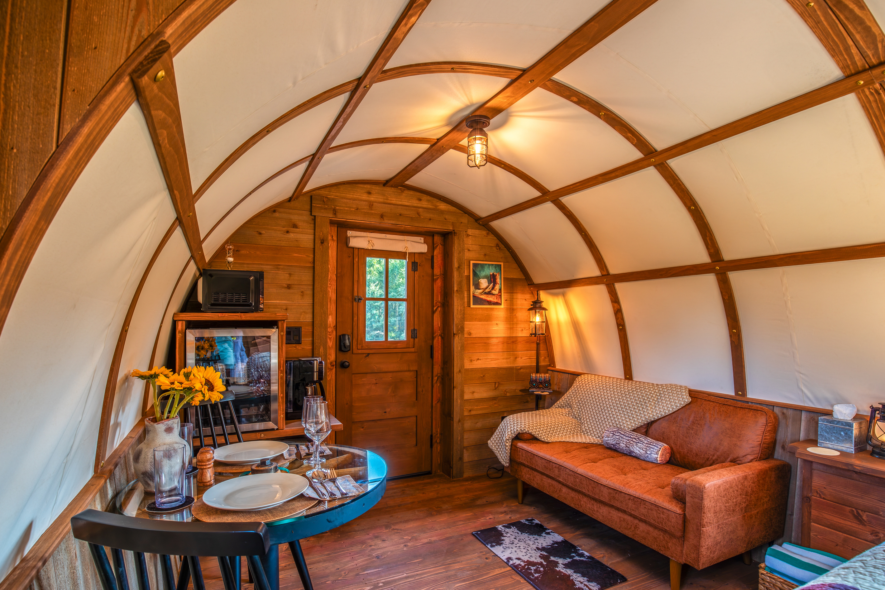 Comfortable sitting area, dining table, coffee station, and rustic western details inside the wagon.