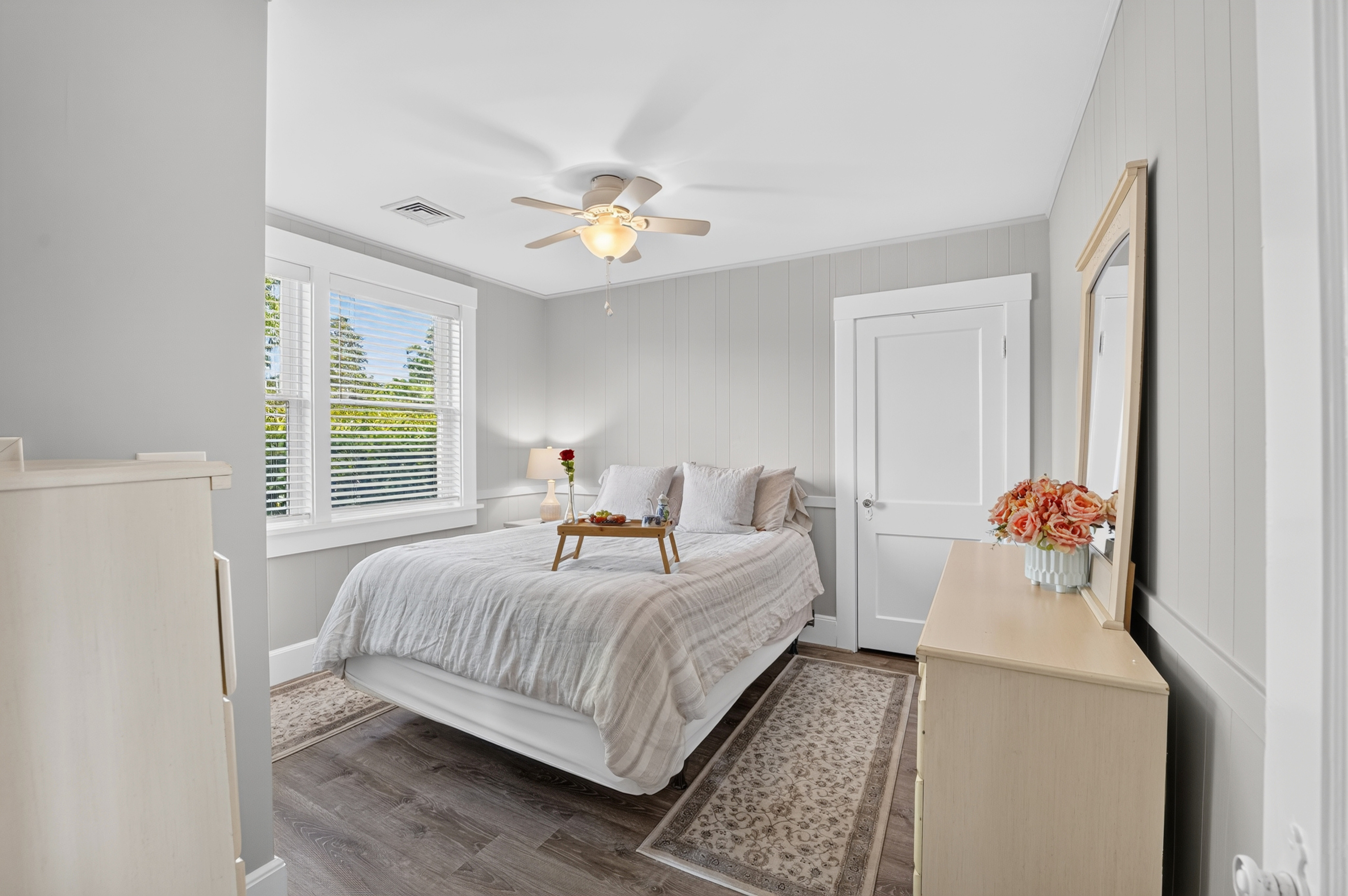 Spacious bedroom featuring comfortable furnishings, abundant natural light, and plenty of storage.
