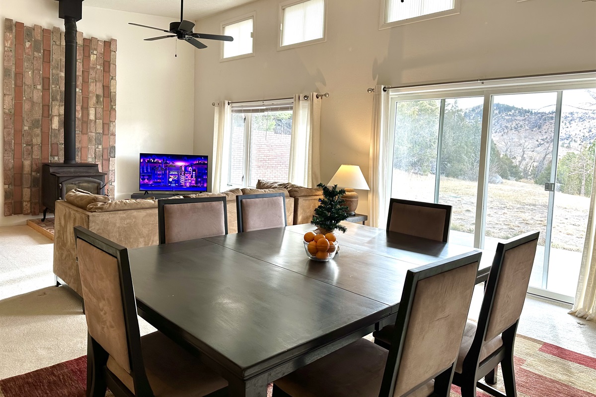 The dining room is part of the open-layout great room. Enjoy a meal or play games and take in the quiet beauty of Montana through the large picture windows overlooking the mountains.